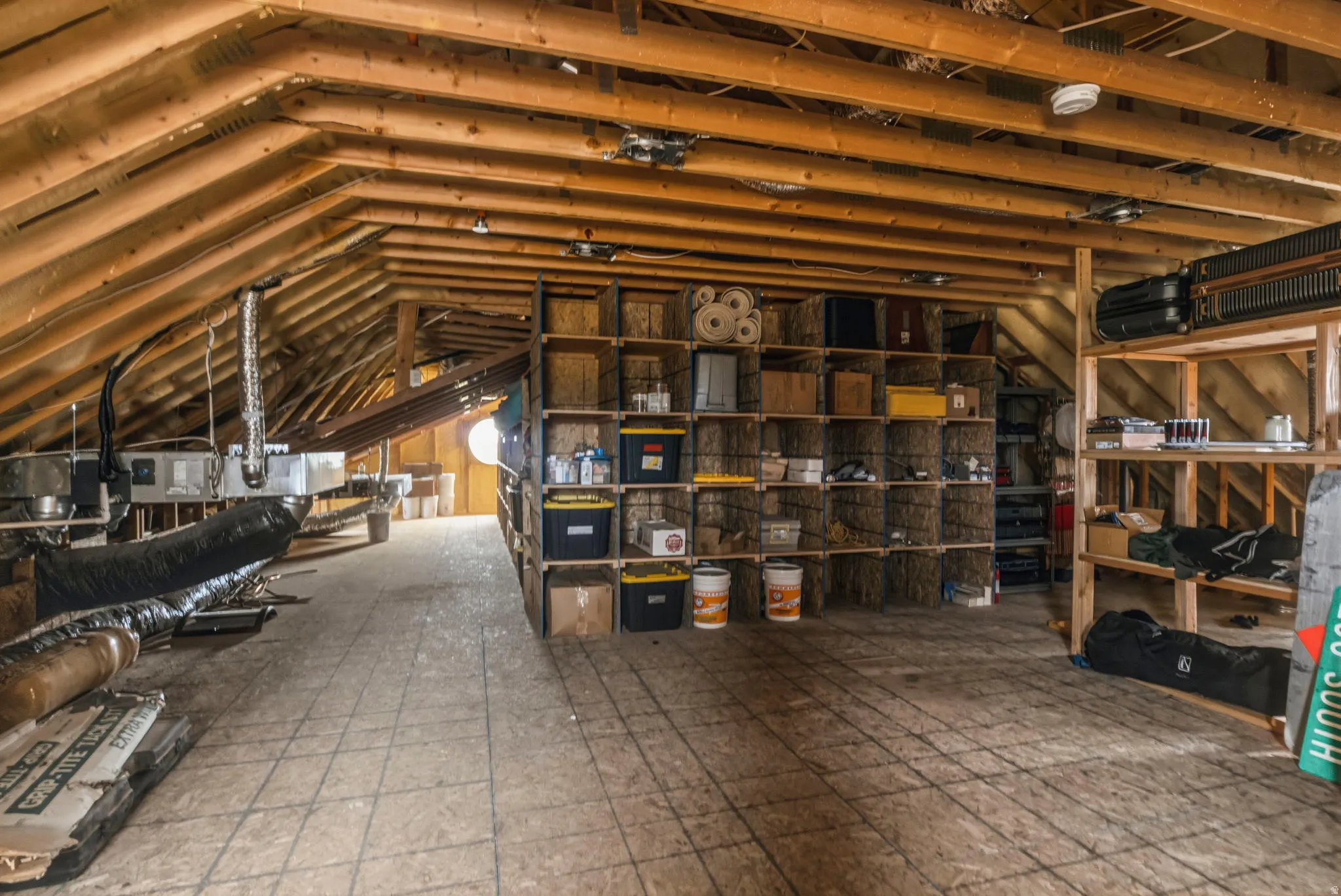 Spacious attic area featuring exposed wooden rafters and ceiling joists