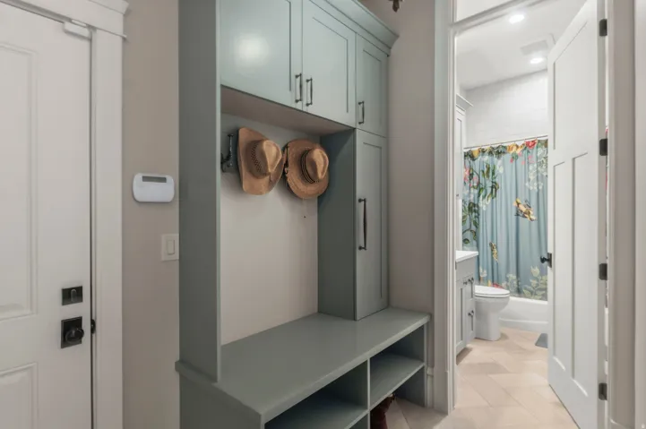 Custom built-in entryway storage right off the garage with shelving and upper cabinetry