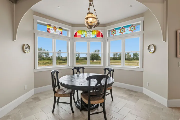Bay window with stained glass transoms and white trim surround this extra breakfast nook