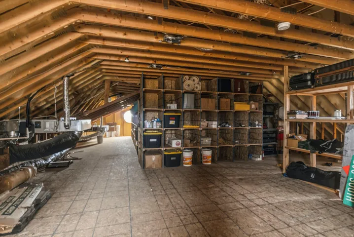 Spacious attic area featuring exposed wooden rafters and ceiling joists