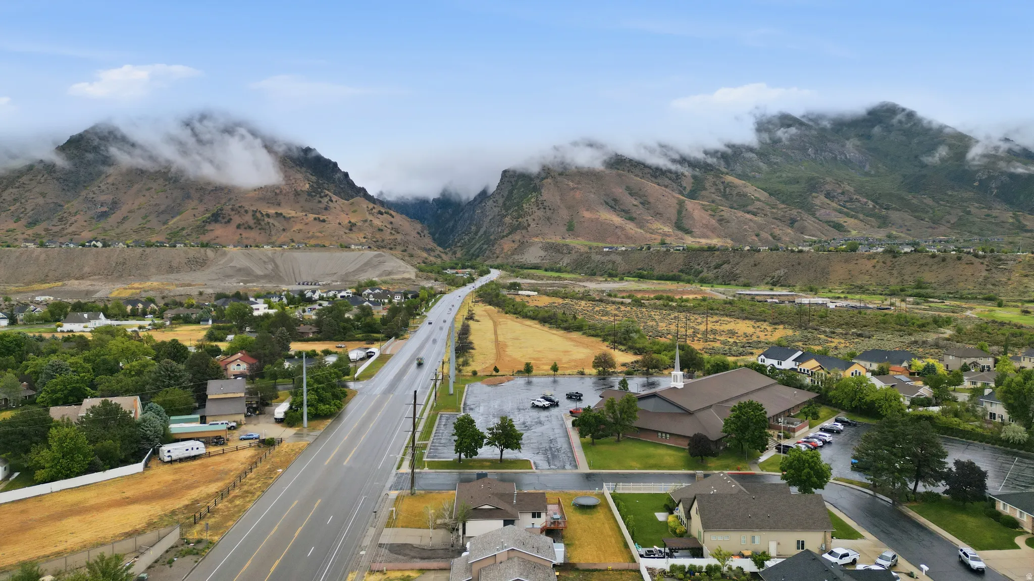 Expansive mountain range backdrop with residential homes situated among mature trees