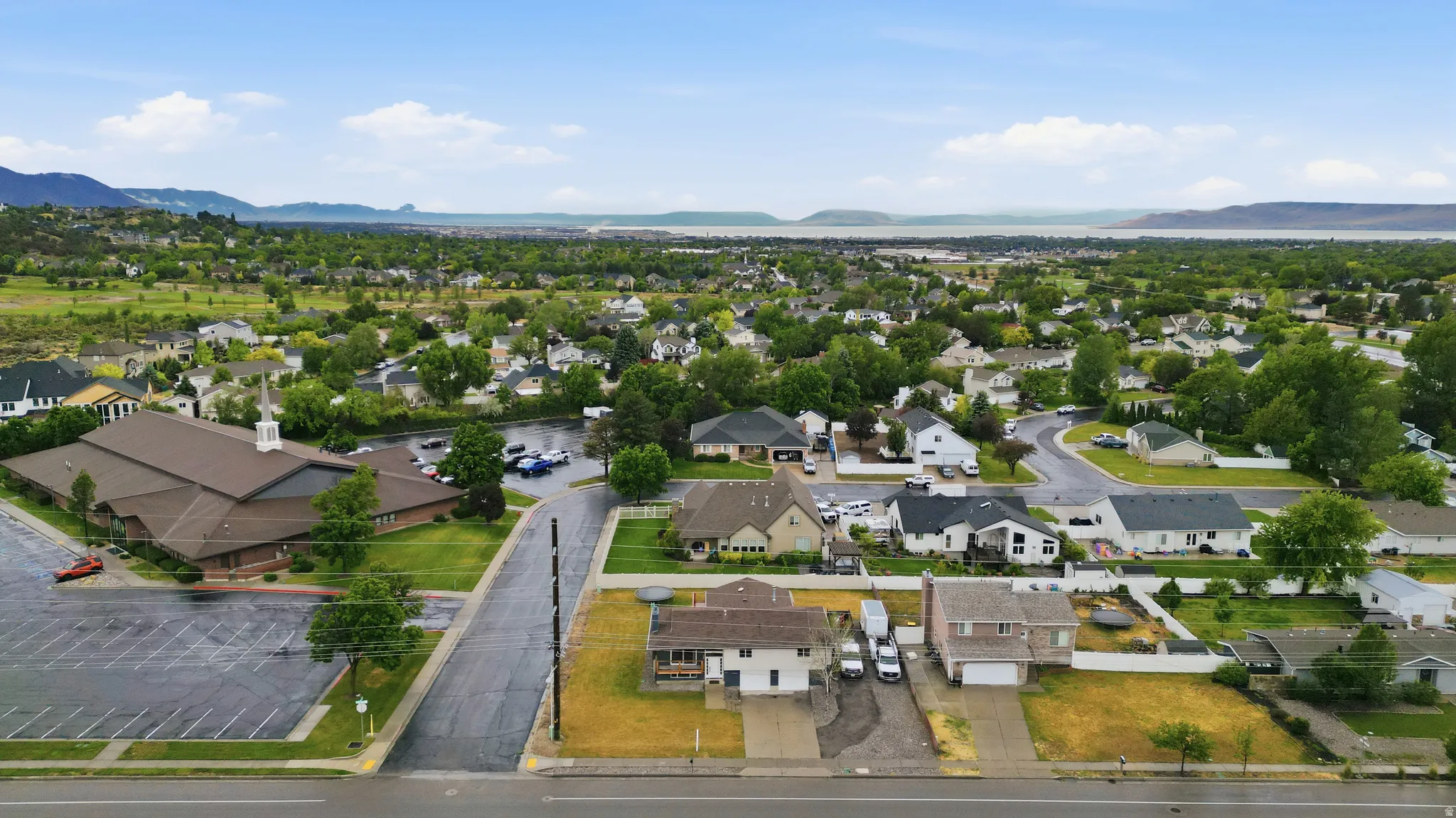 Aerial perspective showcasing a residential neighborhood with a distant body of water and mountains