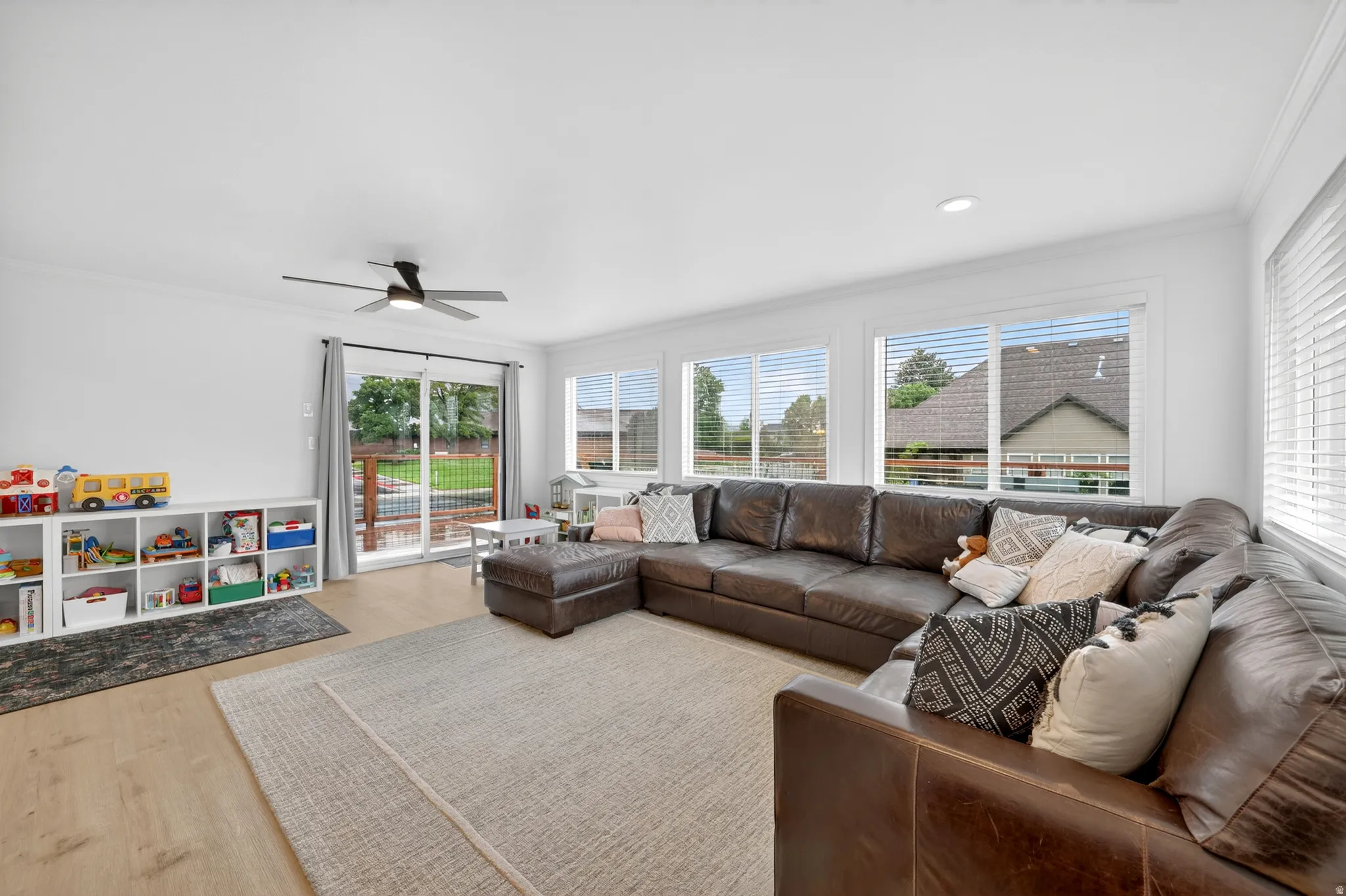 Spacious living area featuring wood-finish flooring and abundant natural light from multiple windows