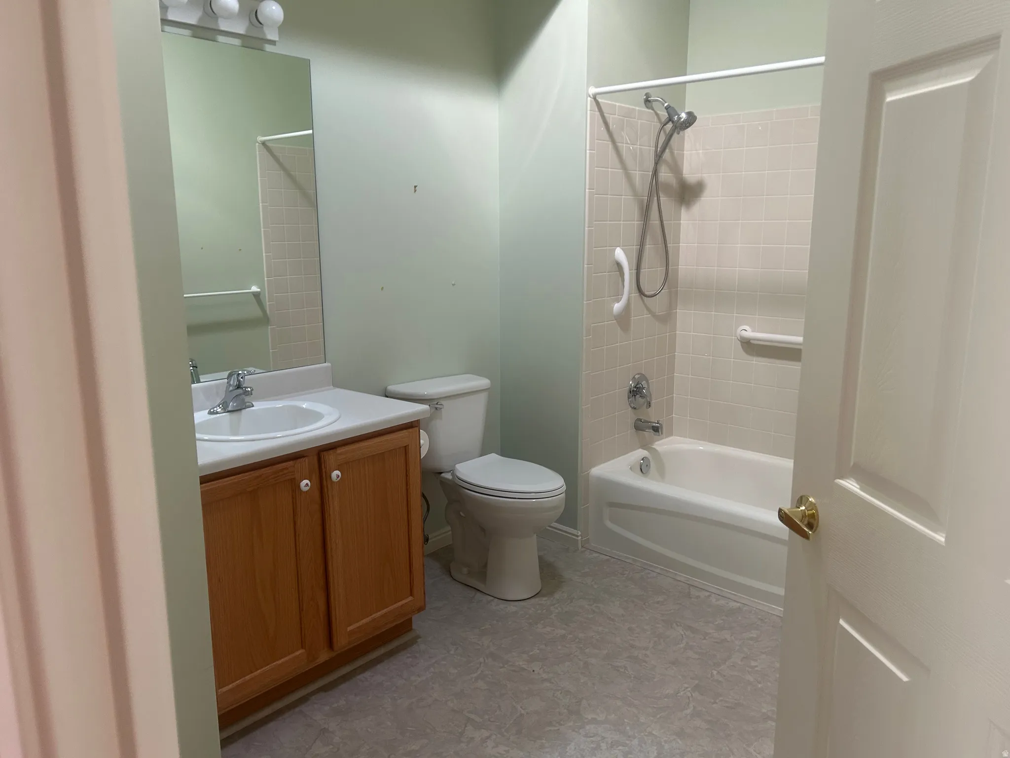 Guest bathroom featuring a full vanity with wood-finish cabinetry, a white basin, and a mirrored medicine cabinet