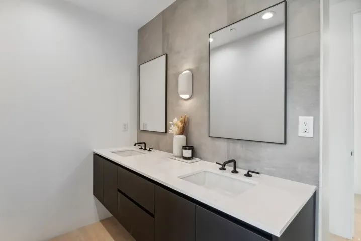 Floating double vanity with integrated sinks, white countertops, matte black faucets, and rectangular mirrors