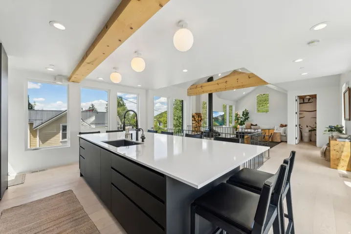 Modern kitchen island featuring a white countertop, undermount sink with a matte black faucet, and seating for two