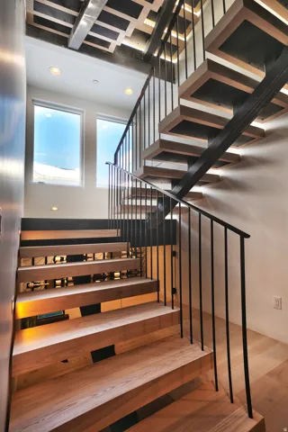 Modern open-riser staircase featuring wood-finish treads and risers with integrated lighting