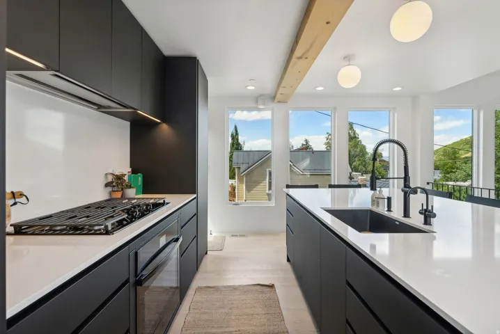 Contemporary kitchen featuring a gas range, built-in oven, and under-cabinet lighting