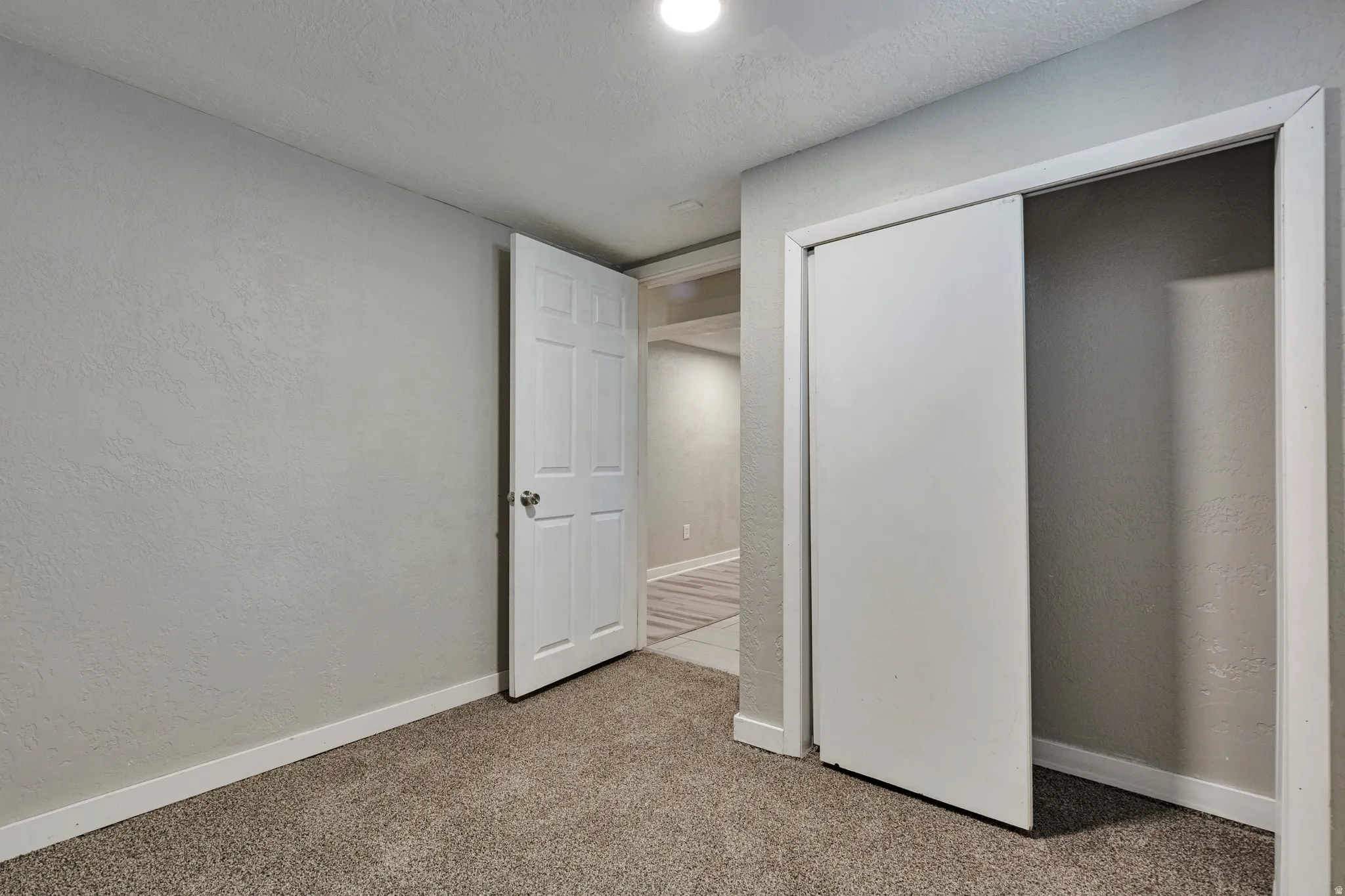 Bedroom featuring neutral tone walls, white trim, recessed lighting, and carpet flooring