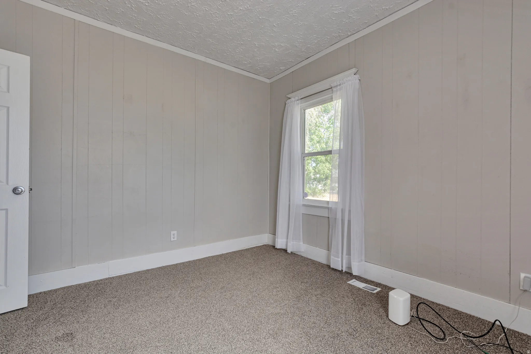 Windowed interior space featuring light grey vertical paneling and coordinating baseboards