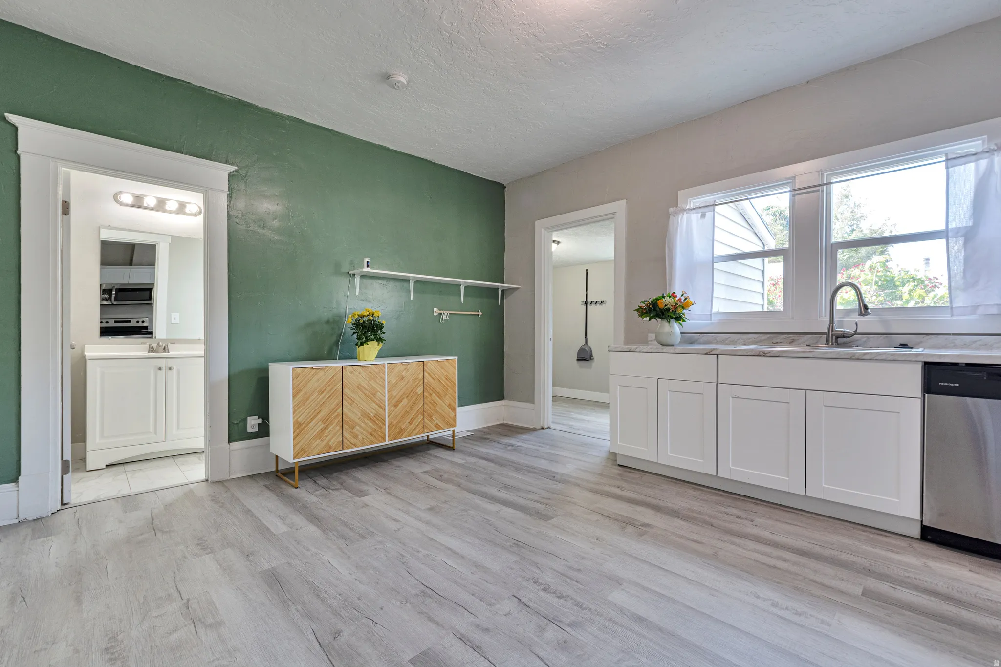 Light wood-finish flooring provides a neutral base for the green accent wall