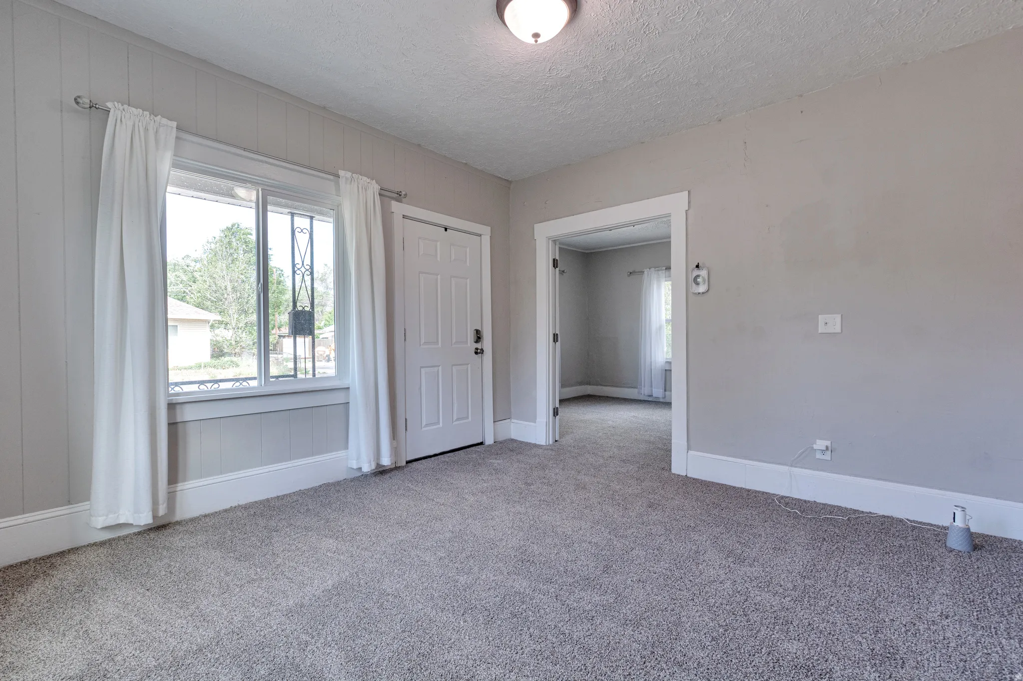 Spacious room featuring light gray carpeting and a neutral wall color