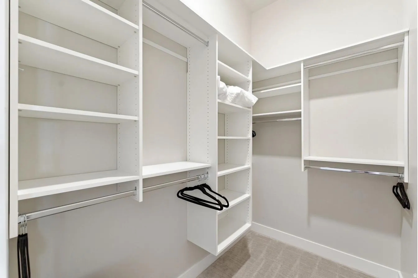 Custom closet system featuring white shelving and chrome hanging rods