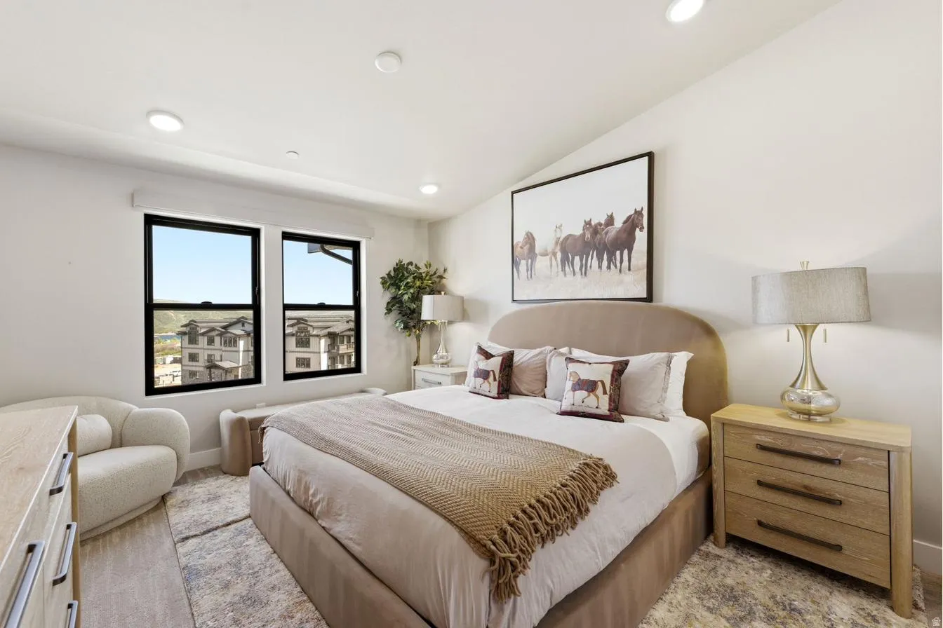 Bedroom featuring recessed lighting, a vaulted ceiling, and two large windows with black frames