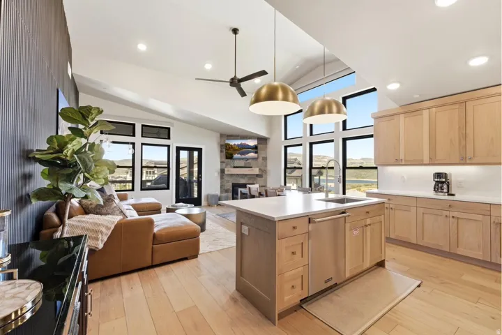 Open-concept living space featuring a gourmet kitchen island with a built-in sink and stainless steel dishwasher