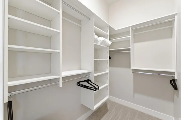 Custom closet system featuring white shelving and chrome hanging rods