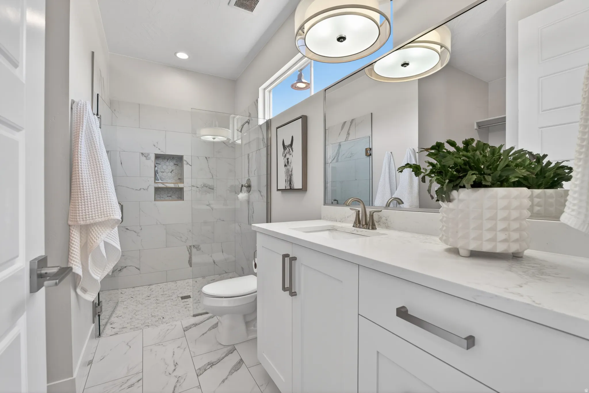 Bathroom featuring a single vanity with stone countertop, white cabinetry, and brushed nickel hardware