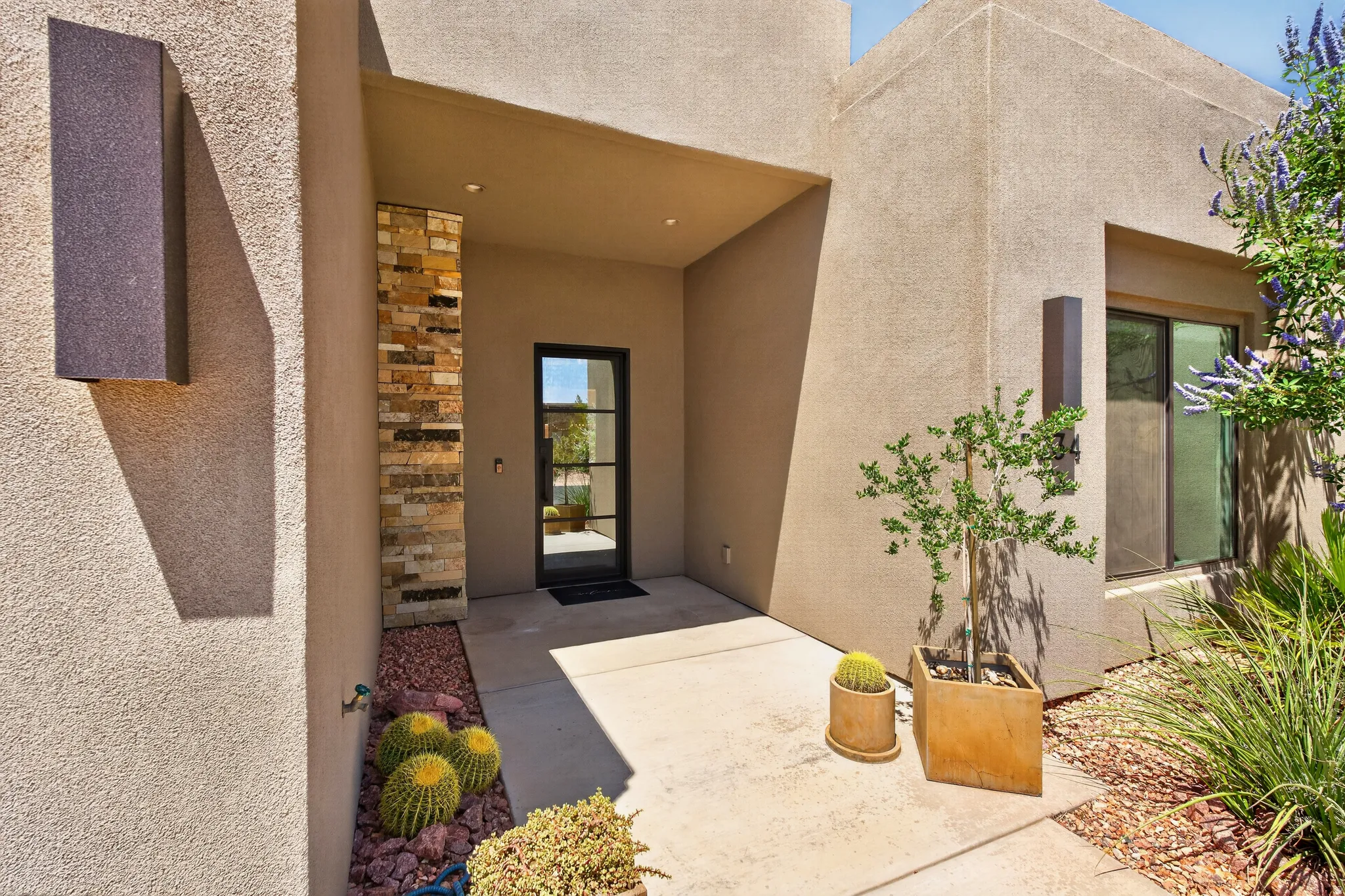 Stucco exterior with stone veneer accents and a recessed entry