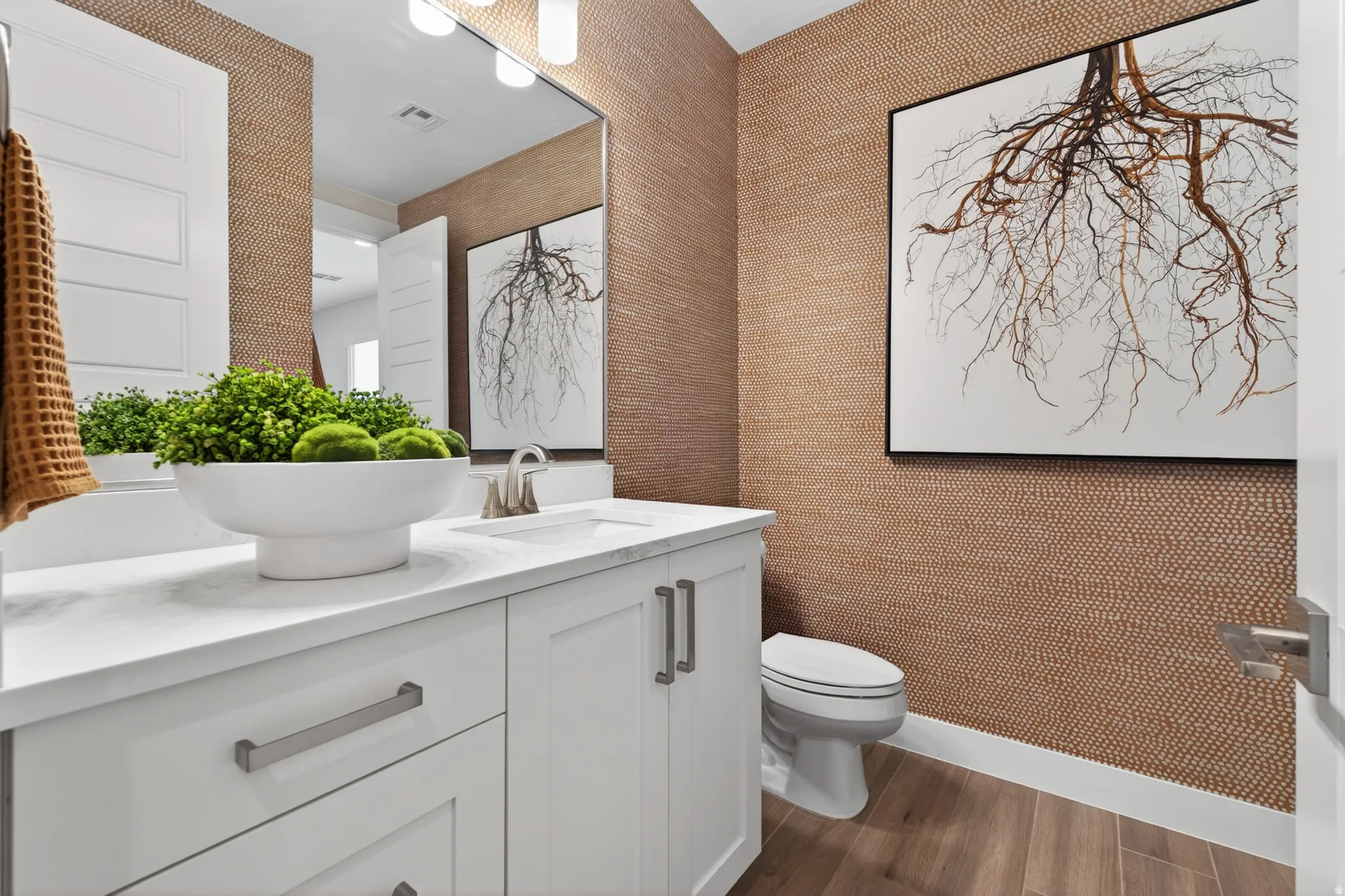 Powder room featuring a white single vanity with a solid surface countertop, brushed nickel faucet, and a large wall-mounted mirror