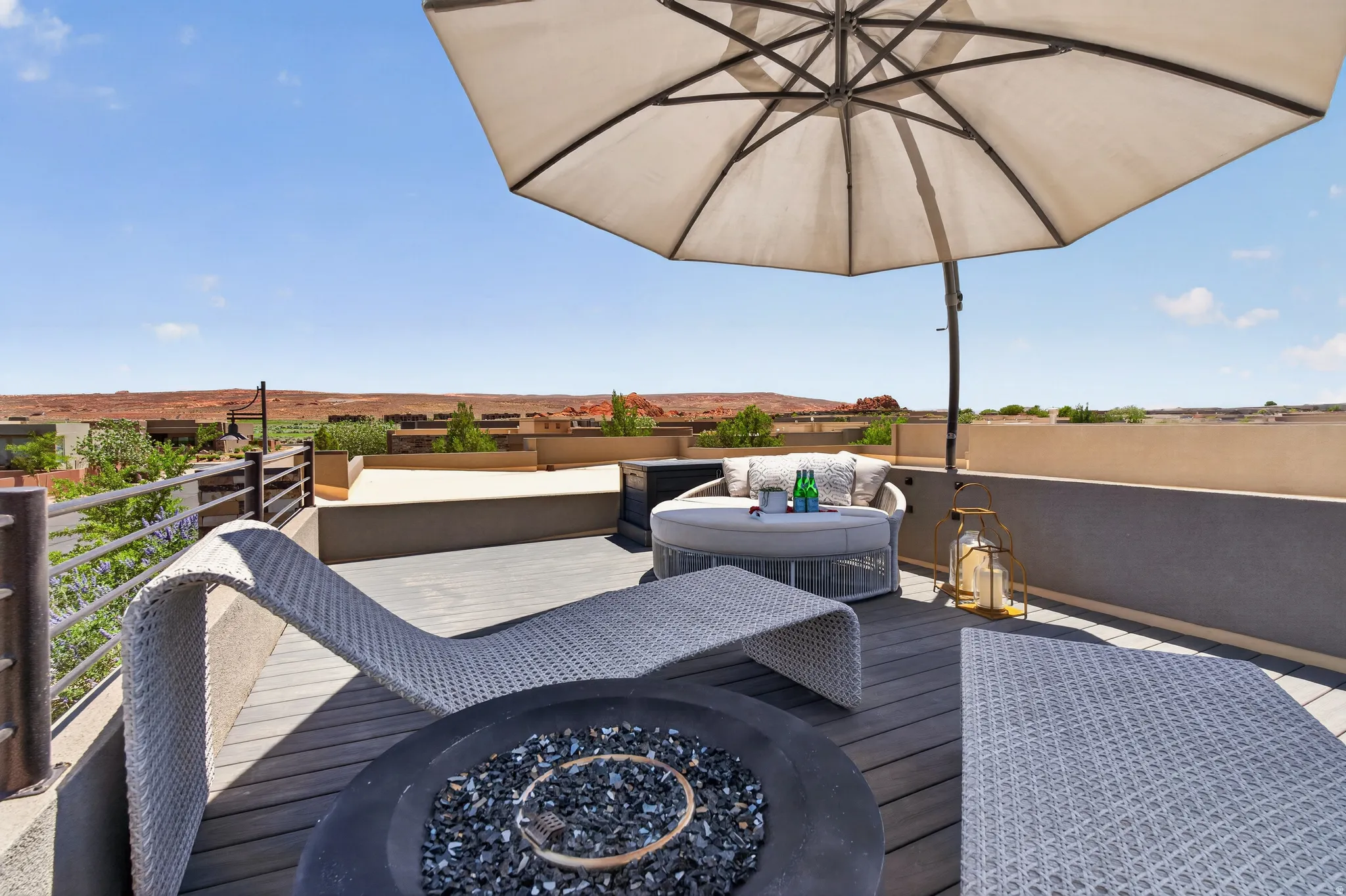 Expansive rooftop deck featuring composite decking, a built-in fire pit, and metal railings