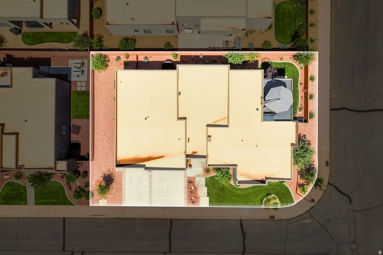 Aerial view of the property showcasing a beige flat roof and a concrete driveway