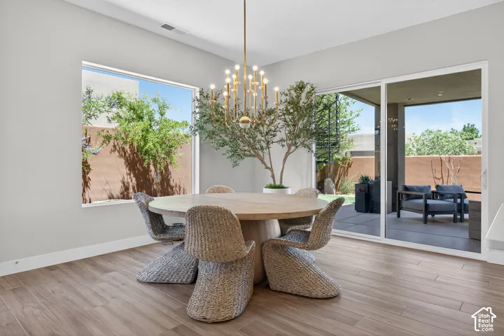 Dining area featuring wood-finish flooring and a contemporary chandelier