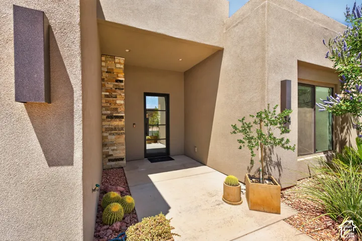 Stucco exterior with stone veneer accents and a recessed entry