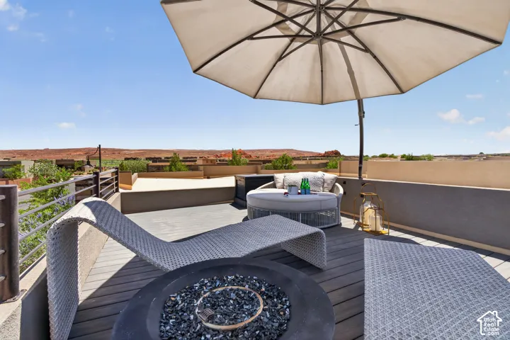 Expansive rooftop deck featuring composite decking, a built-in fire pit, and metal railings