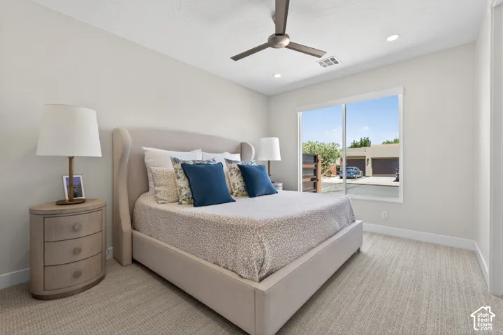 Neutral-toned bedroom featuring wall-to-wall carpeting, recessed lighting, and a contemporary ceiling fan