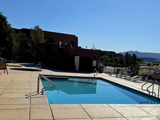 Rectangular swimming pool with integrated steps and handrails, surrounded by a concrete deck