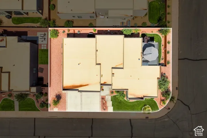 Aerial view of the property showcasing a beige flat roof and a concrete driveway