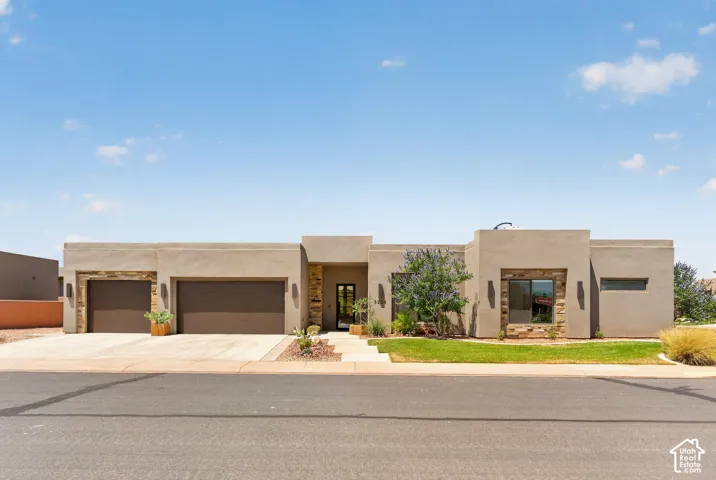 Modern stucco exterior featuring stone accents and a flat roofline
