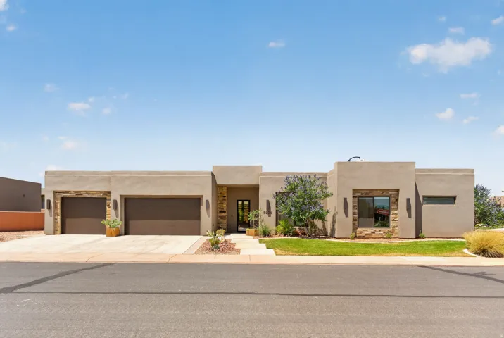 Modern stucco exterior featuring stone accents and a flat roofline