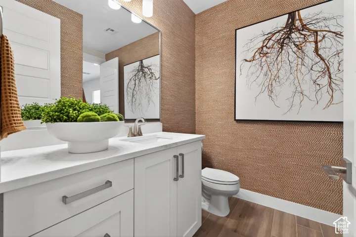 Powder room featuring a white single vanity with a solid surface countertop, brushed nickel faucet, and a large wall-mounted mirror