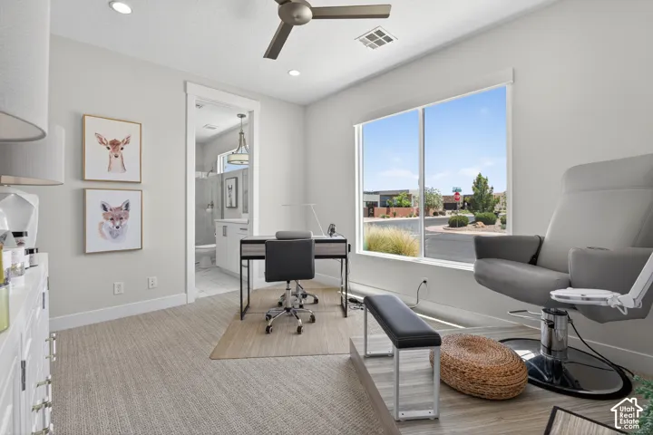 Bright room featuring a large window, recessed lighting, and a ceiling fan