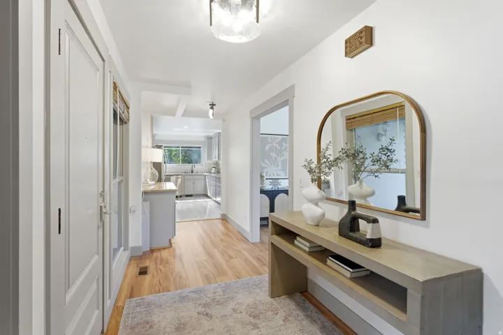 Hallway featuring wood-finish flooring, white walls, and a recessed ceiling light fixture