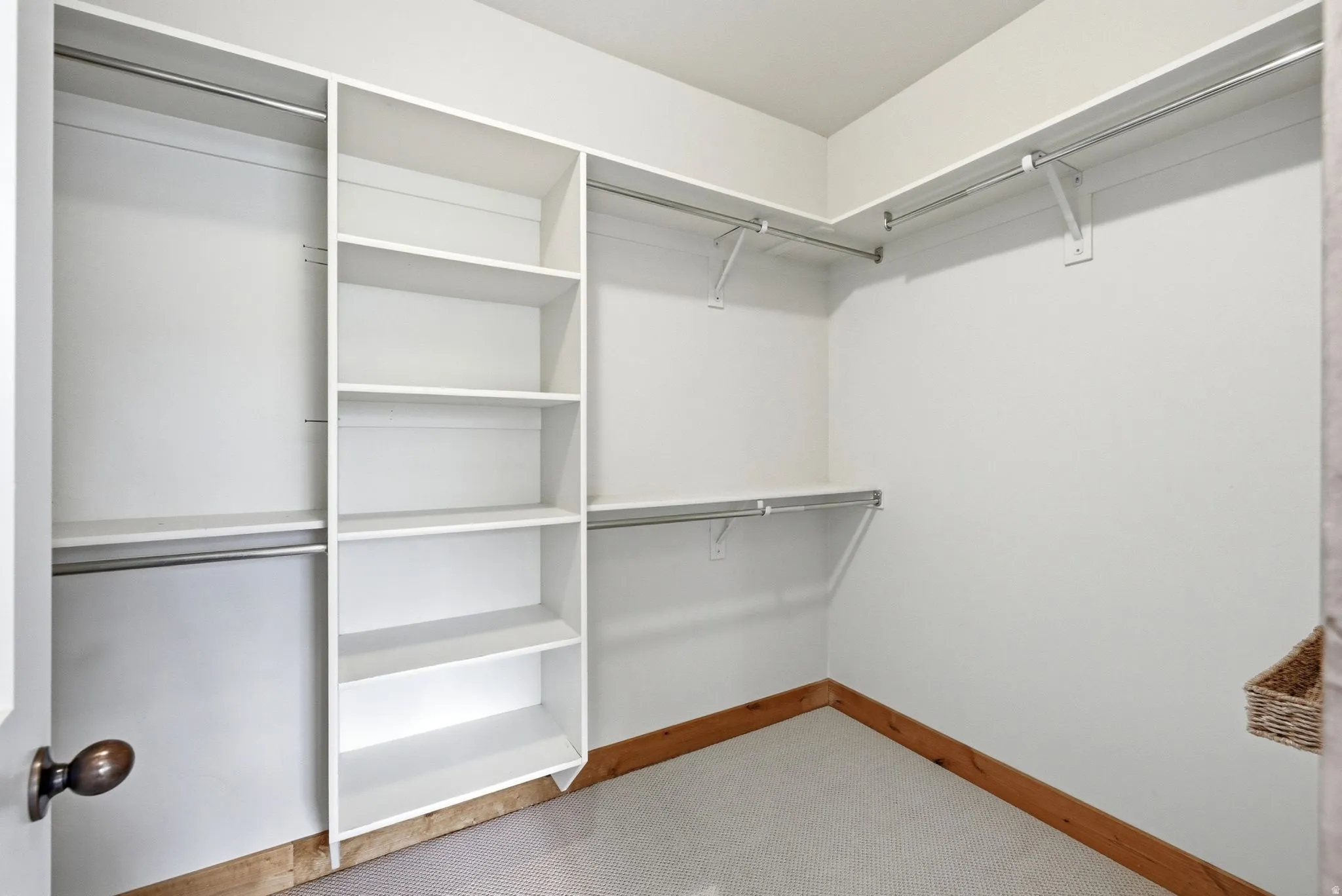 Integrated closet system featuring multiple hanging rods, adjustable shelving, and built-in storage