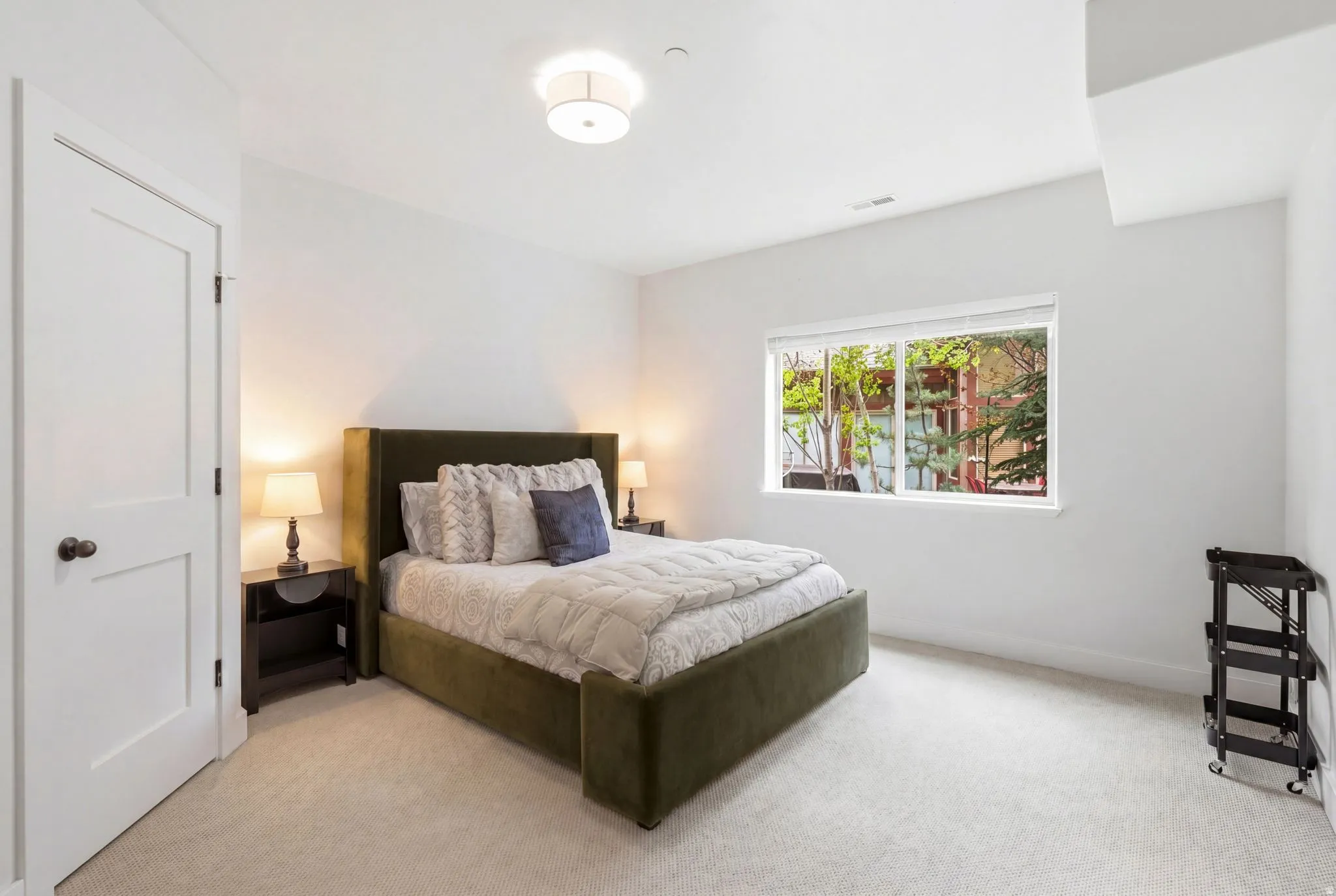 Carpeted room with a large window and neutral wall tones