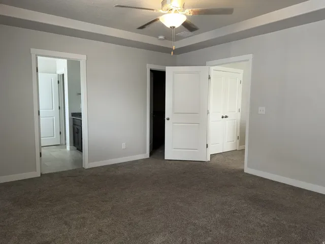 Carpeted interior space featuring light gray walls and white trim