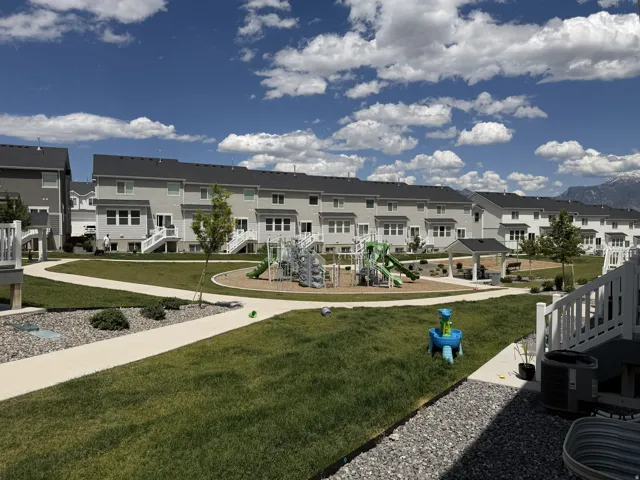 Central green space featuring a playground, shaded gazebo, and paved walking paths