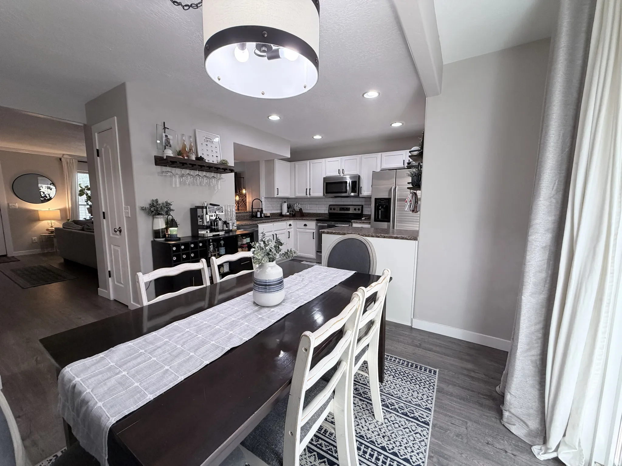 Open-concept dining area with wood-finish flooring, recessed lighting, and a modern ceiling fixture