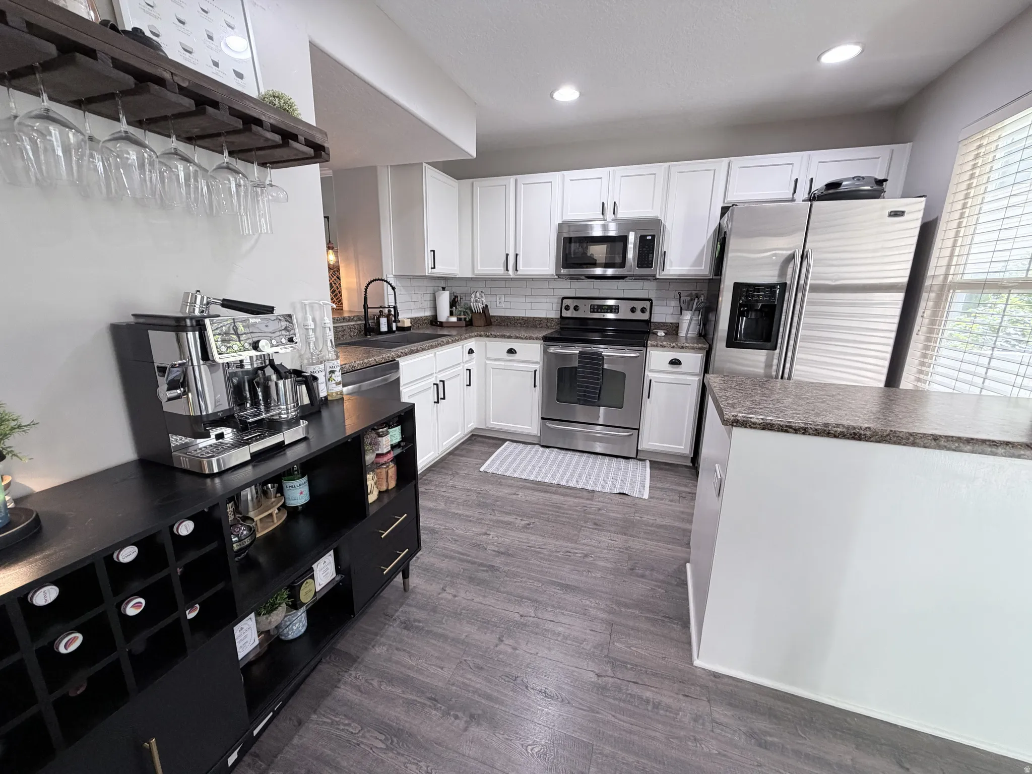 Contemporary kitchen featuring white cabinetry and stainless steel appliances