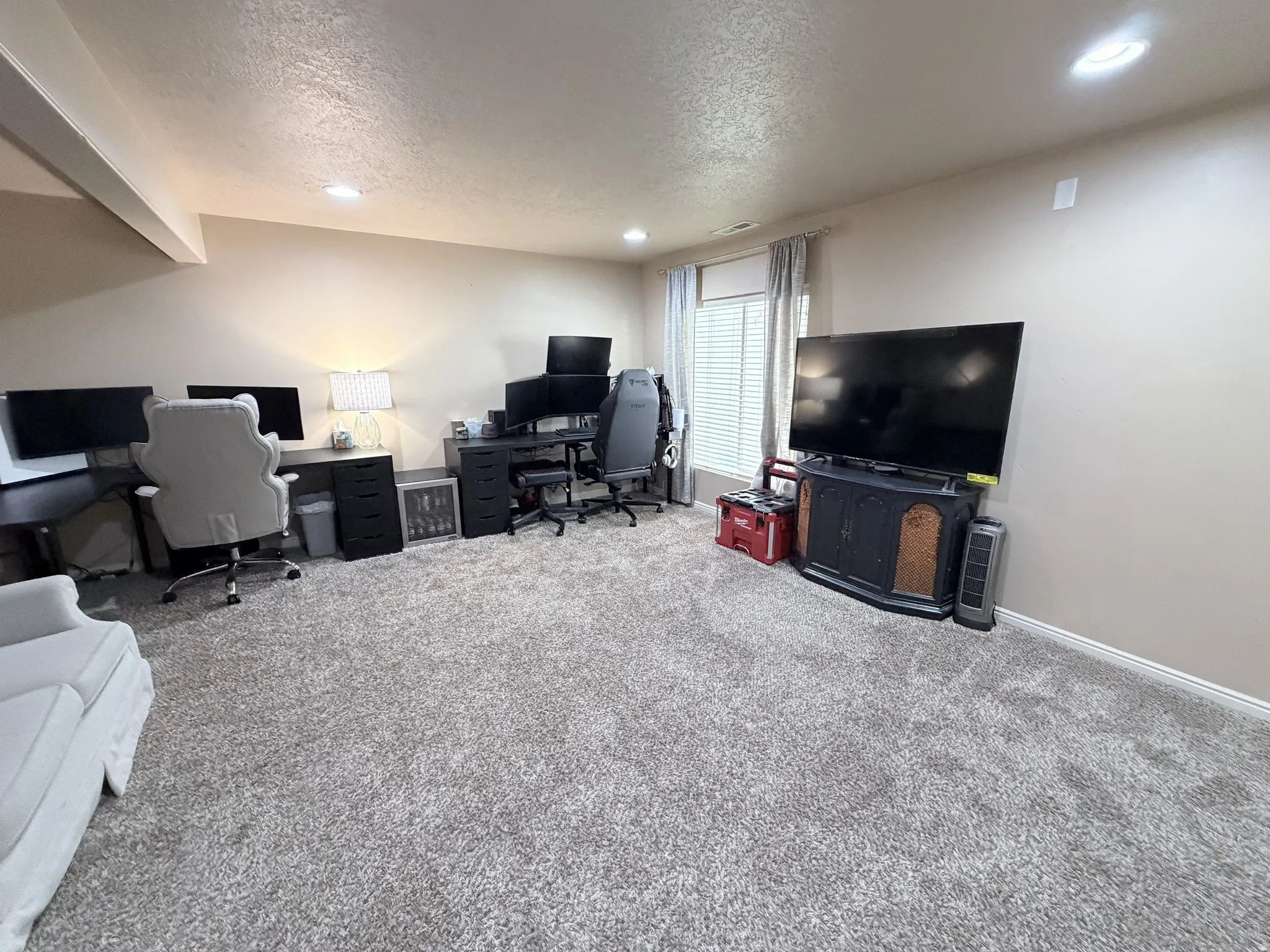 Spacious room featuring plush carpeting, neutral wall tones, and recessed lighting