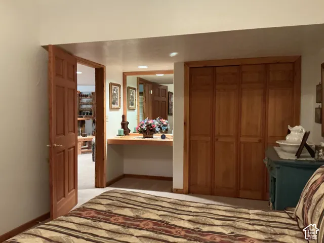 Wood-paneled bi-fold closet doors, recessed lighting, and a built-in vanity with mirror