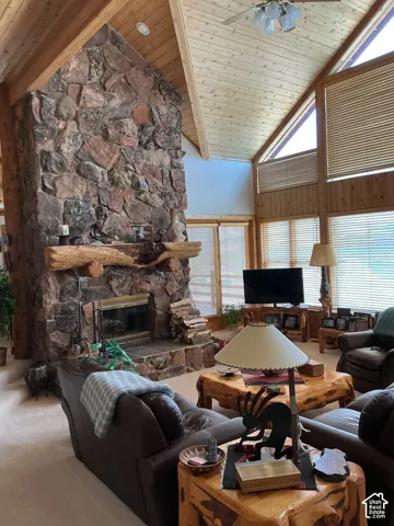 Soaring vaulted wood-plank ceilings frame a floor-to-ceiling stone fireplace with a rustic wood mantel