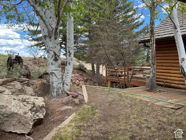 Log cabin exterior featuring a natural wood deck and railing