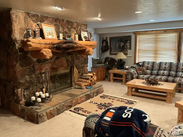 Floor-to-ceiling stone fireplace featuring a substantial log mantel and a stone hearth
