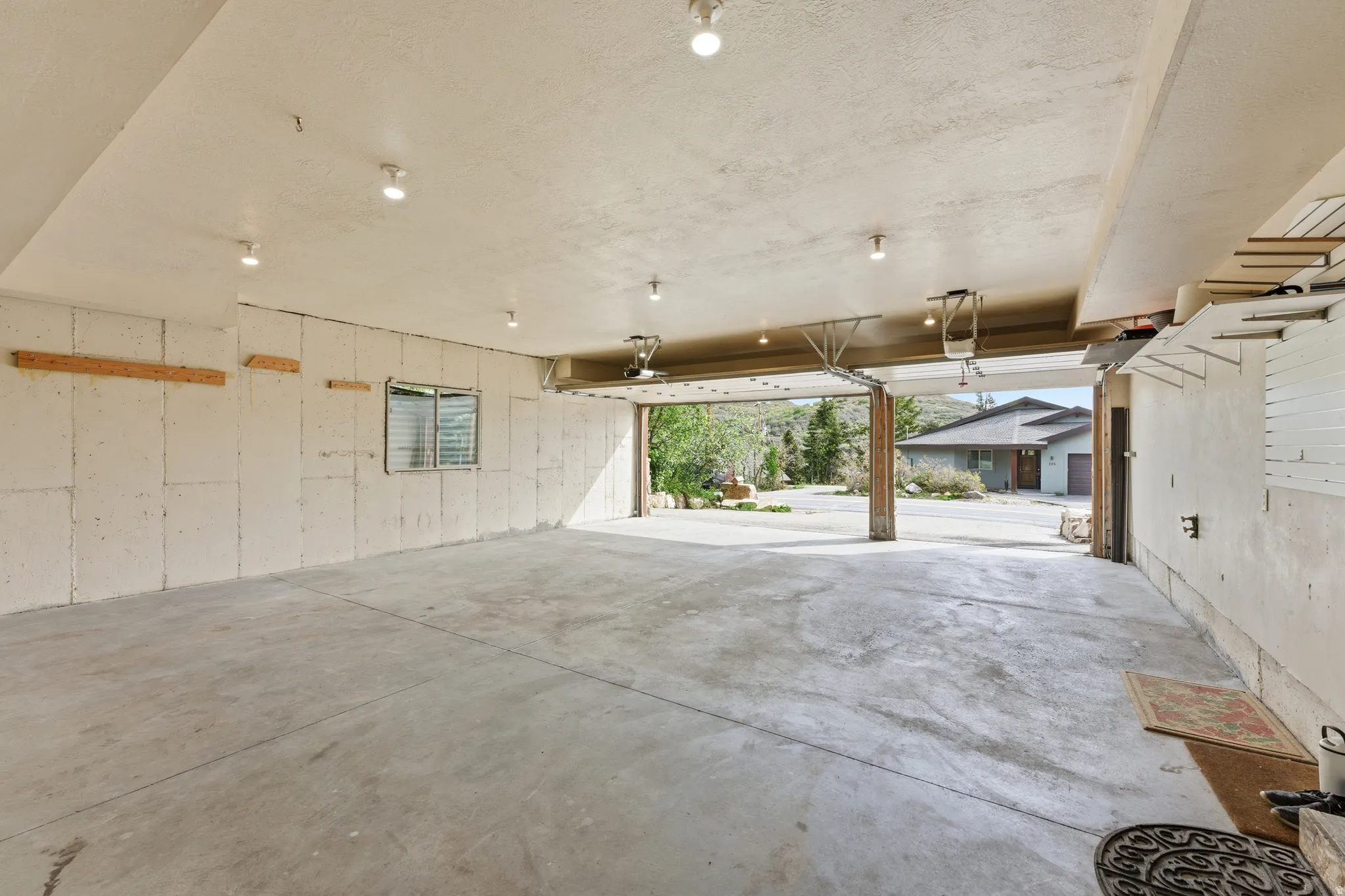 Spacious garage featuring a concrete floor, abundant recessed lighting, and a window for natural illumination