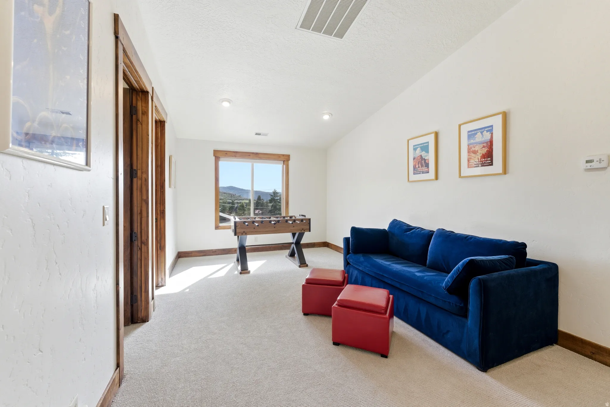 Carpeted room featuring a window with mountain scenery, recessed lighting, and wood-finish door frames and trim