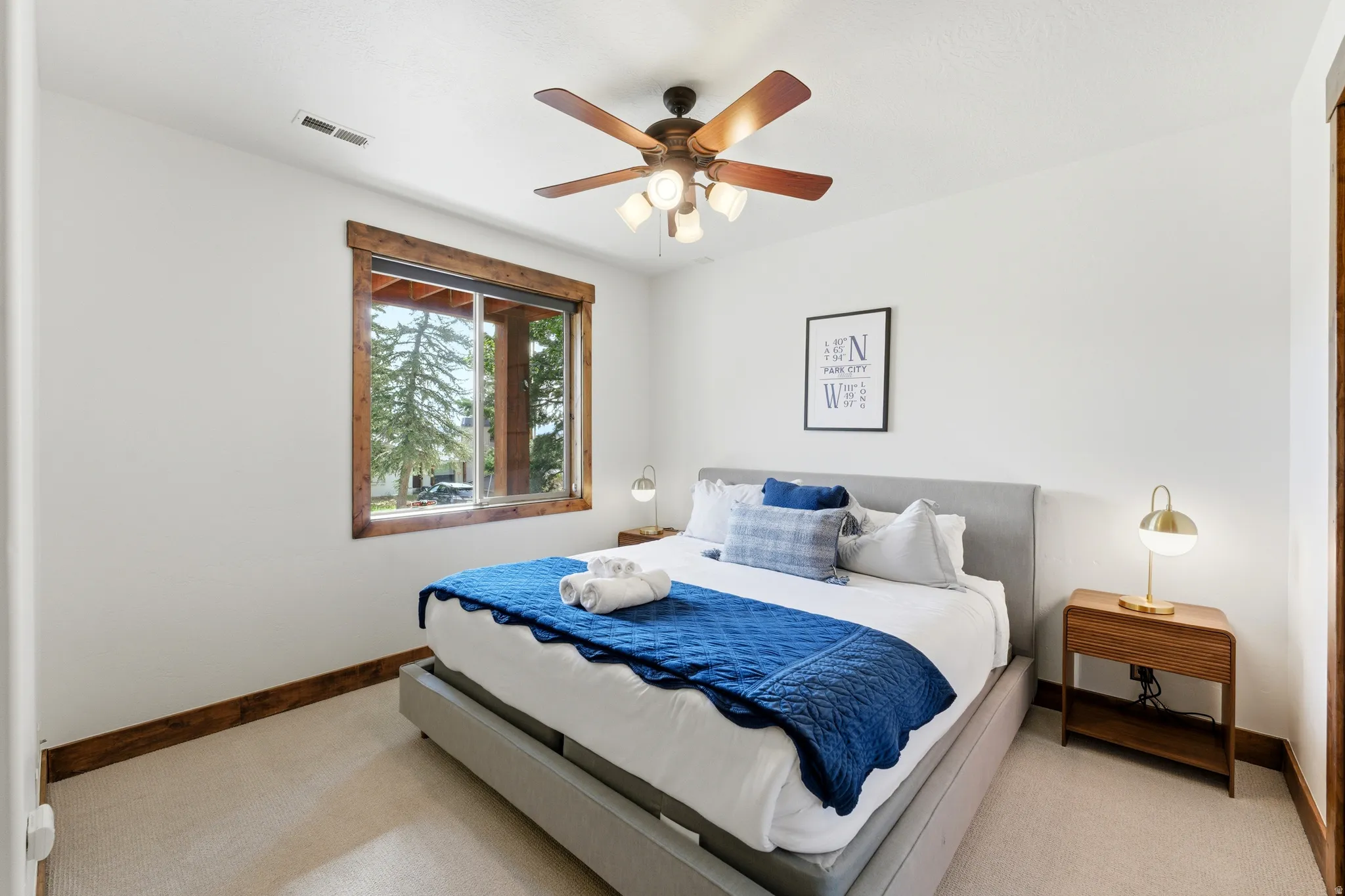 Bedroom featuring a ceiling fan with integrated lighting, wood-finish window trim, and baseboards